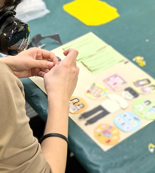 手で紙をちぎり、ちぎり絵を制作する様子